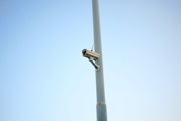 security camera hanging on power pole isolated on blue background