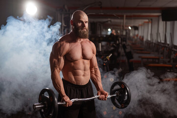 Wall Mural - Caucasian bald topless man doing an exercise with a barbell in the gym. Bicep curls with weights.