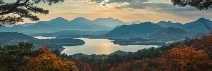 Canvas Print - A beautiful mountain range with a lake in the foreground. The sun is setting, casting a warm glow over the landscape. The scene is peaceful and serene, with the mountains