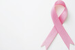 © Bonsales - Pink ribbon symbolizing breast cancer awareness placed on a plain white background. The image represents hope, support, and the fight against cancer