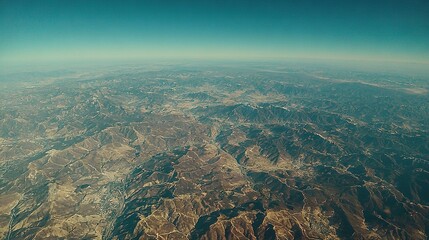 Poster -   A bird's-eye view of desert mountains rising from the arid landscape below