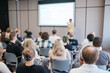 © Anton Gvozdikov - Group of people listening to speaker during presentation in conference setting. Engaged audience in seminar room focused on lecturer.