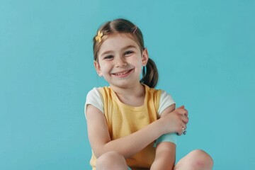 Wall Mural - A young girl sits on the floor holding a TV remote control, perfect for illustrations of childhood leisure or entertainment