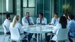 © Felippe Lopes - A group of doctors in white coats are sitting around a table and discussing something.