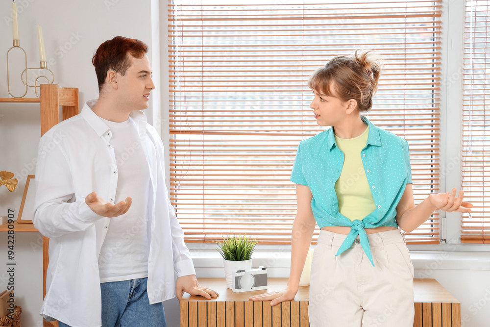 Young man with hearing aid and his girlfriend quarreling at home