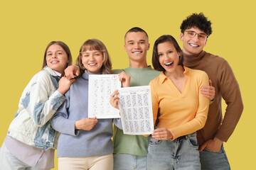 Wall Mural - Group of students with results of exam on yellow background