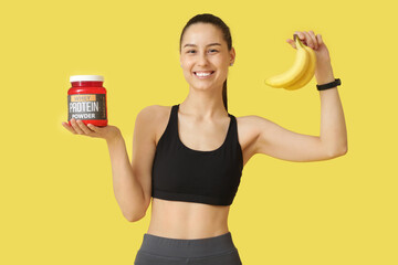 Poster - Sporty young happy woman with jar of protein powder and bananas on yellow background