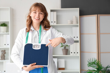 Sticker - Female nutritionist pointing at weight scales in office