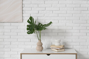 Canvas Print - Modern interior of living room with tropical monstera leaves in vase on chest of drawers, closeup