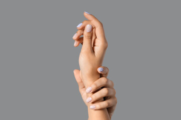 Wall Mural - Female hands with beautiful manicure against grey background, closeup