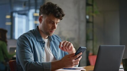 Poster - Focused businessman looking smartphone reading messages at laptop table closeup