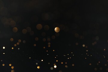 Wall Mural - Beautiful shiny golden glitter on black background, closeup