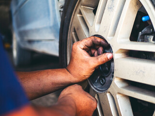 Wall Mural - Mechanic man hands checking car tires outdoor on site service auto garage for automotive mobile center services. Technician workshop repair checking tyres car motor vehicles service mechanical hands