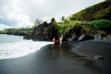 Crazy girls posing on black beach, Maui, Hawaii