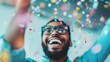 © red_orange_stock - A smiling man in glasses celebrates with vibrant confetti falling around him, capturing a joyful and festive moment.