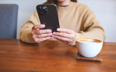 Canvas Print - Closeup image of a young woman holding and using mobile phone