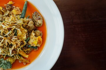 Flat lay shot of a plate of Hawker-style Oyster Omelette containing stir-fried oyster and fried egg, bean sprout, and some vegetables with chili sauce