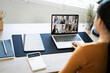 © NAMPIX - Back view of female employee speak talk on video call with colleagues  online, woman worker have Webcam group conference with coworkers on modern laptop at home