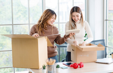 Portrait two roommates happy young Asian female moving packing things in box into new apartment, carry cardboard boxes, Concept teenage or friends, Real estate property buying, relocation, new home