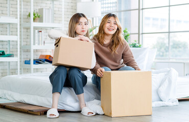 Wall Mural - Portrait two roommates happy young Asian female moving packing things in box into new apartment, carry cardboard boxes, Concept teenage or friends, Real estate property buying, relocation, new home