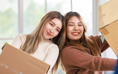 Wall Mural - Portrait two roommates happy young Asian female moving packing things in box into new apartment, carry cardboard boxes, Concept teenage or friends, Real estate property buying, relocation, new home