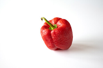 Red, spoiled, wrinkled or overripe bell pepper against white background, no people