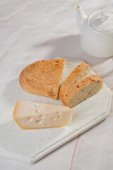 Wall Mural - White bread and hard cheese with holes lie on a light background