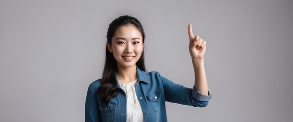 Asian beautiful young woman pointing up one hand with finger on upper side with smile face