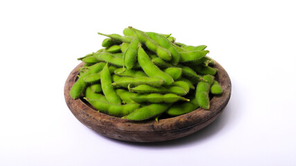 Wall Mural - Fresh edamame beans are placed in a rustic wooden bowl, with ample copy space, isolated on a white background