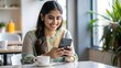 © N7 - 'Joyful Indian Woman Using Smartphone in Cafe' – A smiling Indian woman engrossed in her smartphone while sitting in a modern cafe.