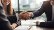 © NewMaii - A professional handshake symbolizing agreement and collaboration in a modern office setting with city view.