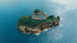 © ADDICTIVE STOCK - Aerial view of a lush green islet with a historic building in the Azores