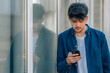 © carballo - young man or boy looking at his mobile phone on the street