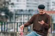 © carballo - young man on the street with mobile phone and skateboard