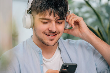 Poster - young man at home with headphones and mobile phone