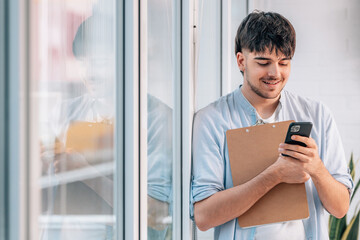 Sticker - young man with mobile phone and documents next to the window