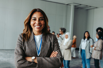 Wall Mural - happy businesswoman smiling at conference with diverse group of professionals in the background