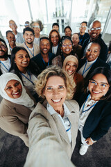 Wall Mural - happy company staff taking a group selfie at the office
