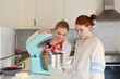 © Olga - mom and daughter teenager in the kitchen preparing dough in a baking mixer