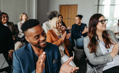 Wall Mural - Multiethnic coworkers applauding and smiling at a workshop