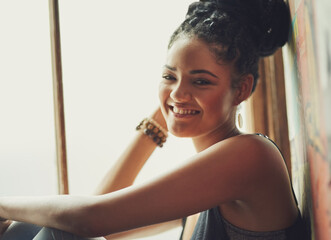 Wall Mural - Happy woman, portrait and relax with braids by window for holiday, weekend or day at indoor cafe. Face of young female person or gen z with smile, positive or carefree attitude in joy at coffee shop