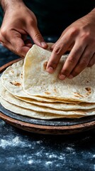 Sticker - closeup of hands folding fresh homemade tortillas on a wooden board with flour dust, mexican cuisine food preparation, rustic kitchen background.