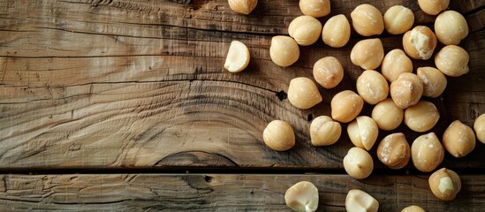 Poster - Macadamia nuts arranged beautifully on a wooden table with copy space image