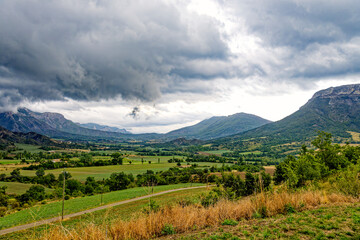 View to a mountain ridge in the French Maritime Alps with haze and heavy cloud cover.