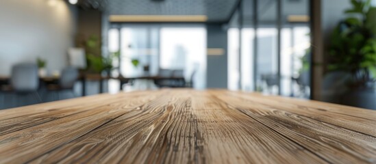 Poster - A wooden office table is positioned in a contemporary office meeting area with a blurry background offering a suitable setting for showcasing products and presentations with copy space image