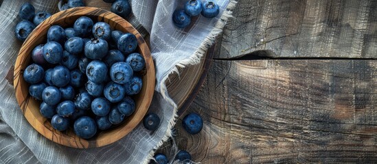 Poster - Top view close up of blueberries displayed on a wooden plate against a rustic cloth background with a blank space for text in the image. Creative banner. Copyspace image