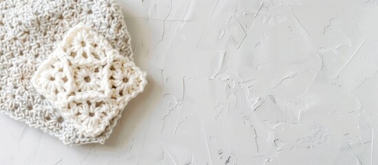 Poster - Crocheted granny square on a white backdrop with a textured pattern providing copy space image