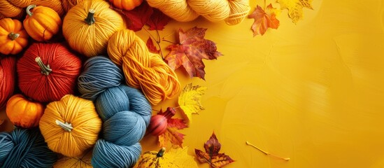 Poster - Autumn themed composition with wool yarn skeins yellow leaves pumpkins and a hand knitting concept for Halloween and autumn creativity includes copy space image