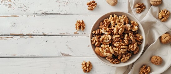 Wall Mural - White wooden background with a bowl of appealing walnuts featuring copy space image