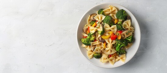 Poster - Top down view of a dish featuring farfalle pasta roasted broccoli and sauteed mushrooms in a bowl on a white backdrop with empty space for text or images. Creative banner. Copyspace image